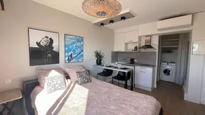 a living room with a bed and a kitchen at Studio 3étoiles à 10 min du Centre - Calme in Cannes