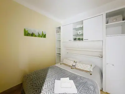 a small bedroom with a bed and shelves at 1-bedroom apartment with sea view on La Croisette in Cannes