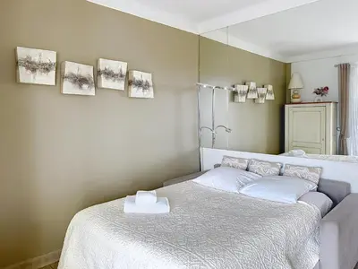 a bedroom with a bed and a mirror at 1-bedroom apartment with sea view on La Croisette in Cannes