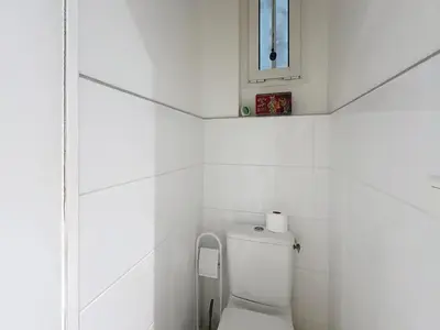 a white bathroom with a toilet and a window at 1-bedroom apartment with sea view on La Croisette in Cannes