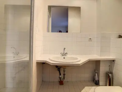 a white bathroom with a sink and a mirror at Pura Vida in Cannes