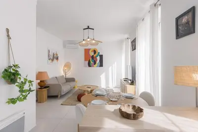 a white living room with a table and a couch at Josi - 2 chambres, central, 10mn du Palais&Plages, neuf, clim in Cannes