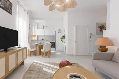 a living room with a couch and a tv and a table at Josi - 2 chambres, central, 10mn du Palais&Plages, neuf, clim in Cannes