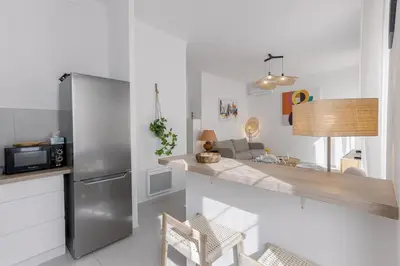 a kitchen with a stainless steel refrigerator and a counter at Josi - 2 chambres, central, 10mn du Palais&Plages, neuf, clim in Cannes