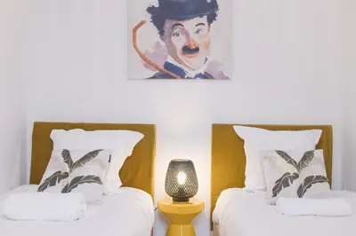 two beds in a room with a painting on the wall at Josi - 2 chambres, central, 10mn du Palais&Plages, neuf, clim in Cannes