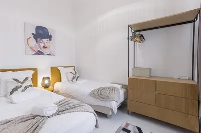 a bedroom with two beds and a dresser in it at Josi - 2 chambres, central, 10mn du Palais&Plages, neuf, clim in Cannes