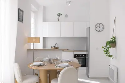 a kitchen and dining room with a wooden table and chairs at Josi - 2 chambres, central, 10mn du Palais&Plages, neuf, clim in Cannes