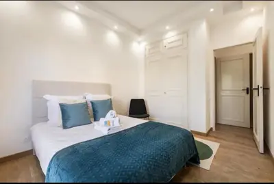 a bedroom with a large bed with a blue blanket at Appartement haut standing - Luxury apartment - Cannes- Croisette- Centre ville- Vue Tennis -Vue Piscine -Parking privé - Terrasse- Plage in Cannes