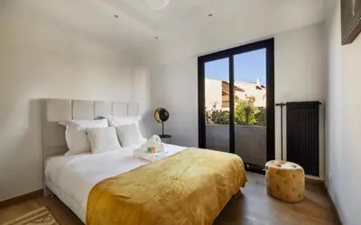a bedroom with a large bed and a large window at Appartement haut standing - Luxury apartment - Cannes- Croisette- Centre ville- Vue Tennis -Vue Piscine -Parking privé - Terrasse- Plage in Cannes