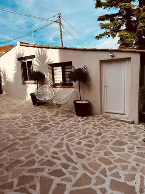 a house with a stone patio in front of it at Le cabanon du Cannet in Le Cannet