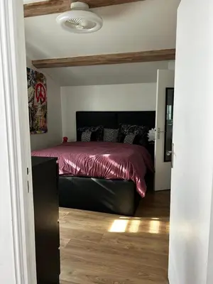 a bedroom with a bed with a red comforter at Le cabanon du Cannet in Le Cannet