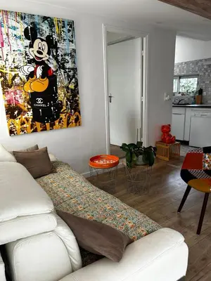 a living room with a couch and a painting on the wall at Le cabanon du Cannet in Le Cannet