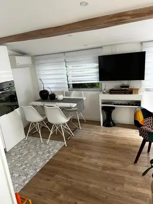 a living room with a table and chairs and a television at Le cabanon du Cannet in Le Cannet