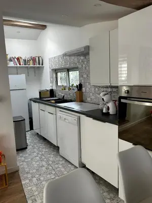 a kitchen with white cabinets and white appliances at Le cabanon du Cannet in Le Cannet