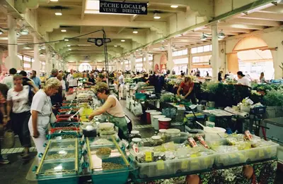 a group of people preparing food in a market at Meynadier 66 - Appartement Très Calme avec Cour Privative, Plage, Gare, Palais à 300m in Cannes