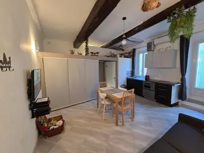 a kitchen and dining room with a table and chairs at Meynadier 66 - Appartement Très Calme avec Cour Privative, Plage, Gare, Palais à 300m in Cannes