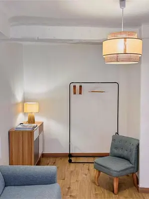 a living room with a chair and a white wall at Studio cosy et luxueux centre Cannes et proche plages in Cannes