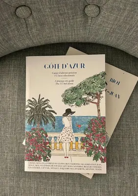a book with a woman standing on a fence with flowers at Studio cosy et luxueux centre Cannes et proche plages in Cannes