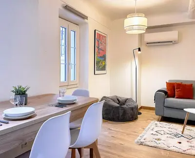 a living room with a table and chairs and a couch at Studio cosy et luxueux centre Cannes et proche plages in Cannes