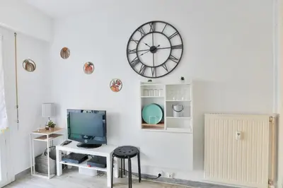 a room with a tv and a clock on the wall at Studio with a 20sqm terrace 10min from la Croisette in Cannes