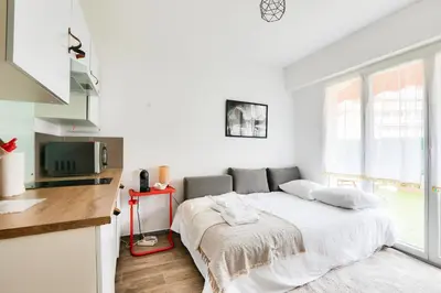 a white bedroom with a bed and a television at Studio with a 20sqm terrace 10min from la Croisette in Cannes