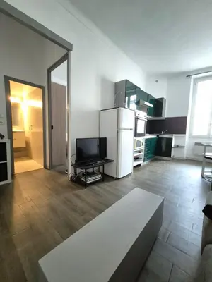 a living room with a white refrigerator and a table at Cannes centre - Vieux port in Cannes