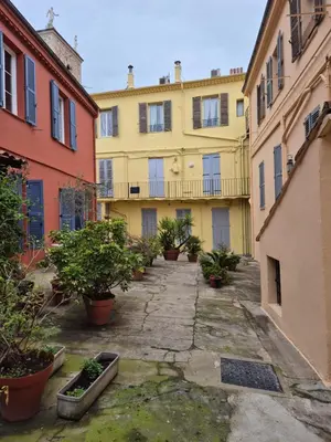 an alley in a building with potted plants at Cannes centre - Vieux port in Cannes