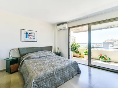 a bedroom with a bed and a large window at Apartment Le Katia-2 by Interhome in Cannes
