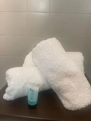a pile of white towels and a cup on a table at Apartment Cannes Croisette near seaside in Cannes