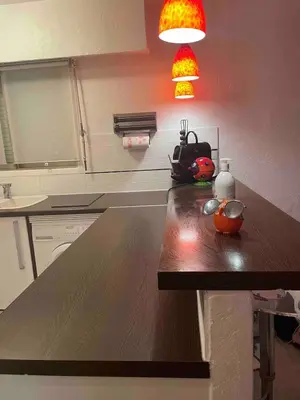 a kitchen with a wooden counter top with a light at Apartment Cannes Croisette near seaside in Cannes