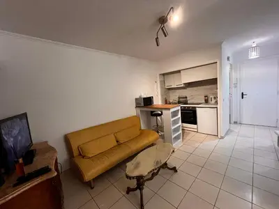 a living room with a couch and a kitchen at Large Studio in Cannes near la Croisette and beach in Cannes