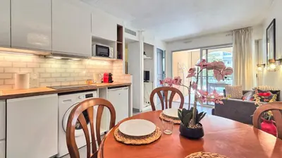 a kitchen and dining room with a table and chairs at LX122 Terrasse, piscine & plage à pied - Cannes in Cannes