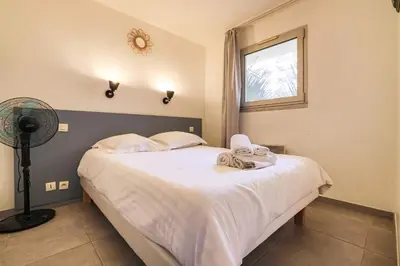 a bedroom with a bed with white sheets and a window at LX122 Terrasse, piscine & plage à pied - Cannes in Cannes