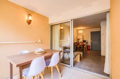 a dining room with a wooden table and white chairs at LX122 Terrasse, piscine & plage à pied - Cannes in Cannes
