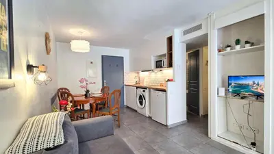 a living room with a kitchen and a dining room at LX122 Terrasse, piscine & plage à pied - Cannes in Cannes