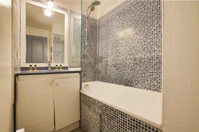a bathroom with a tub and a sink and a mirror at LX122 Terrasse, piscine & plage à pied - Cannes in Cannes