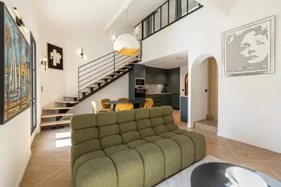 a living room with a couch and a staircase at REF 1993 - Cannes Center Renovated Apartment in Cannes