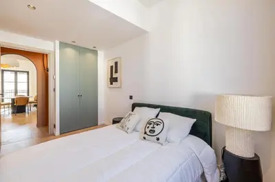 a bedroom with a large white bed with a face painted on it at REF 1993 - Cannes Center Renovated Apartment in Cannes