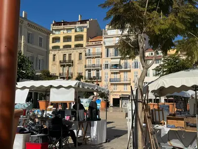 a group of people sitting at tables under white umbrellas at Aparthotel Seaside Cannes Festival Suite in Cannes