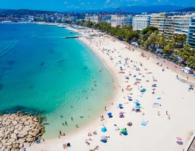 a group of people on a beach in the ocean at Aparthotel Seaside Cannes Festival Suite in Cannes