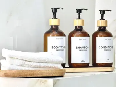 three bottles of soap and towels on a shelf at Aparthotel Seaside Cannes Festival Suite in Cannes