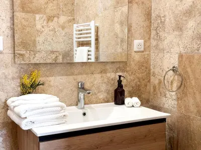 a bathroom with a sink and a mirror and towels at Cannes centre - 10mn Palais, Croisette, Plage - CY in Cannes