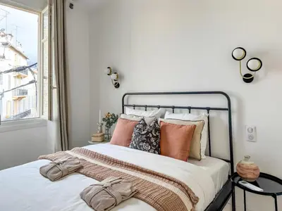 a bedroom with a bed with pillows and a window at Cannes centre - 10mn Palais, Croisette, Plage - CY in Cannes