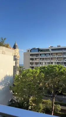 a tall building with a clock tower and a tree at Luxurious Apartment with Sea and Carlton View in Cannes