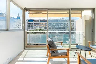a living room with a chair and a large window at Luxurious Apartment with Sea and Carlton View in Cannes