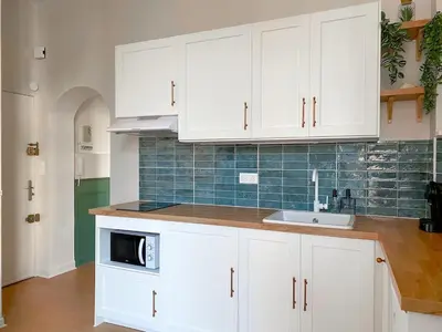 a white kitchen with a sink and a microwave at Charmant 2P avec Balcon, Proche Centre in Cannes