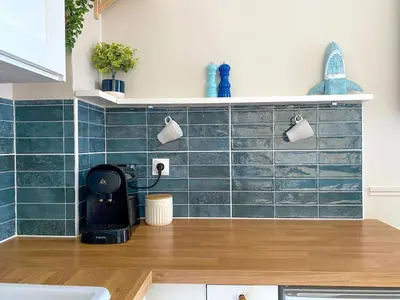 a kitchen with green tiles on the wall at Charmant 2P avec Balcon, Proche Centre in Cannes