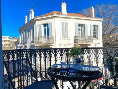 a table on a balcony in front of a building at Charmant 2P avec Balcon, Proche Centre in Cannes