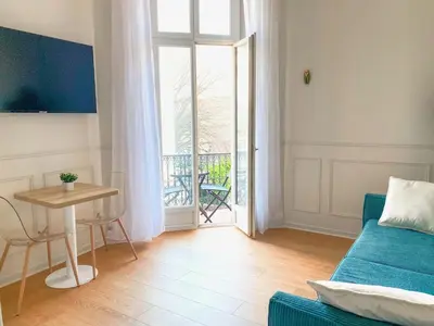 a living room with a couch and a table and a window at Charmant 2P avec Balcon, Proche Centre in Cannes