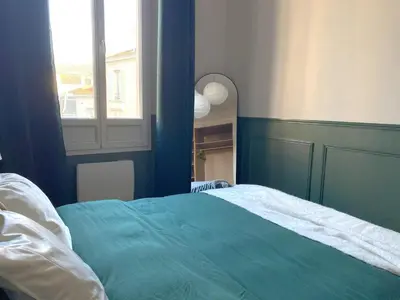 a bedroom with a green bed and a window at Charmant 2P avec Balcon, Proche Centre in Cannes